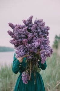 Woman holding bunch of flowers in a field