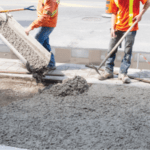 Workers pouring and smoothing concrete